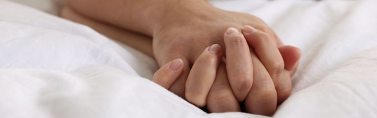Couple holding hands atop their squirting blanket